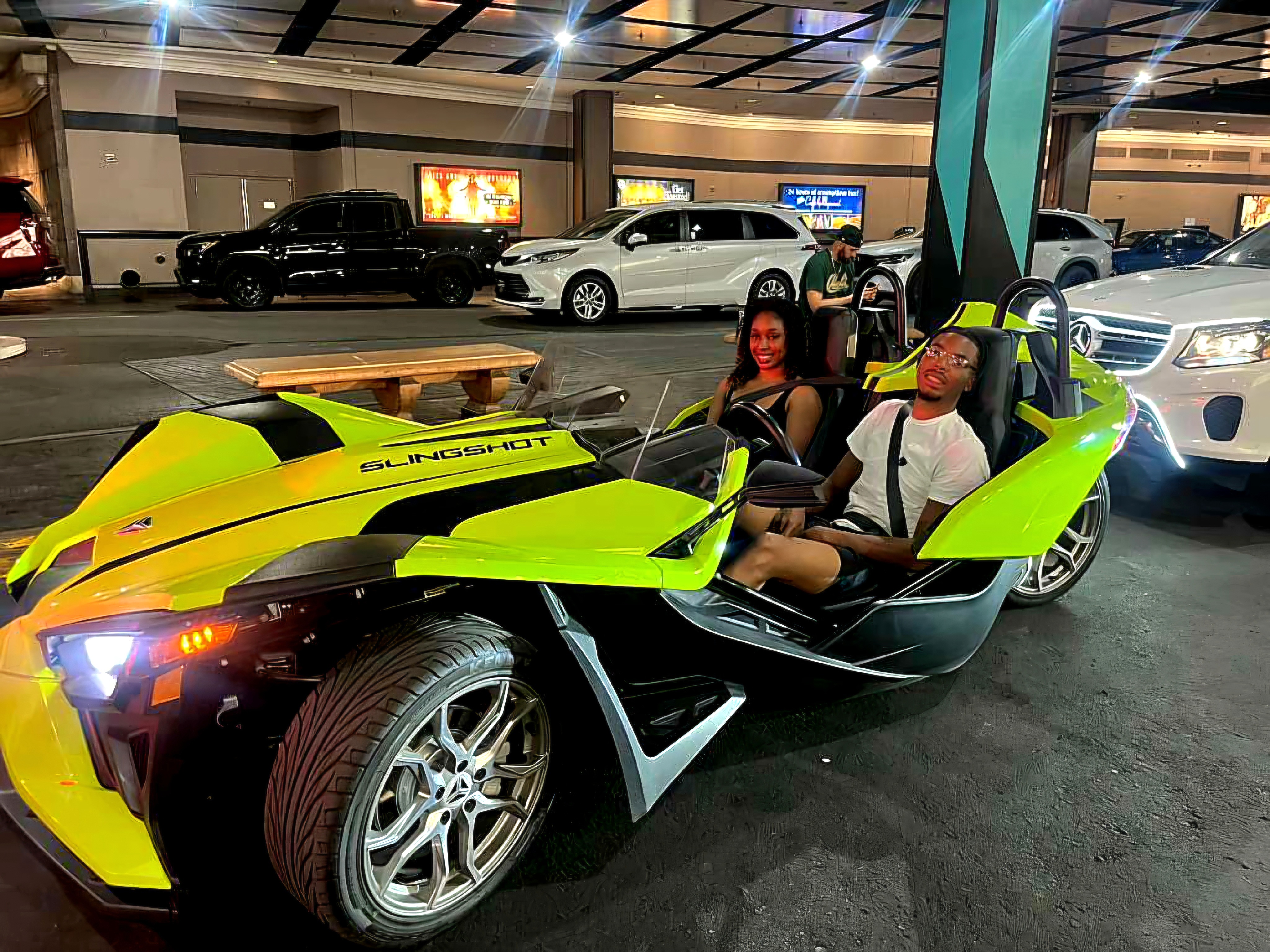 Couple in green Slingshot at night parking garage