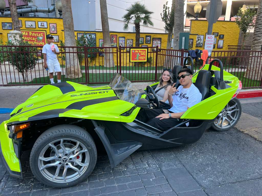 Couple in green Slingshot on Fremont Street