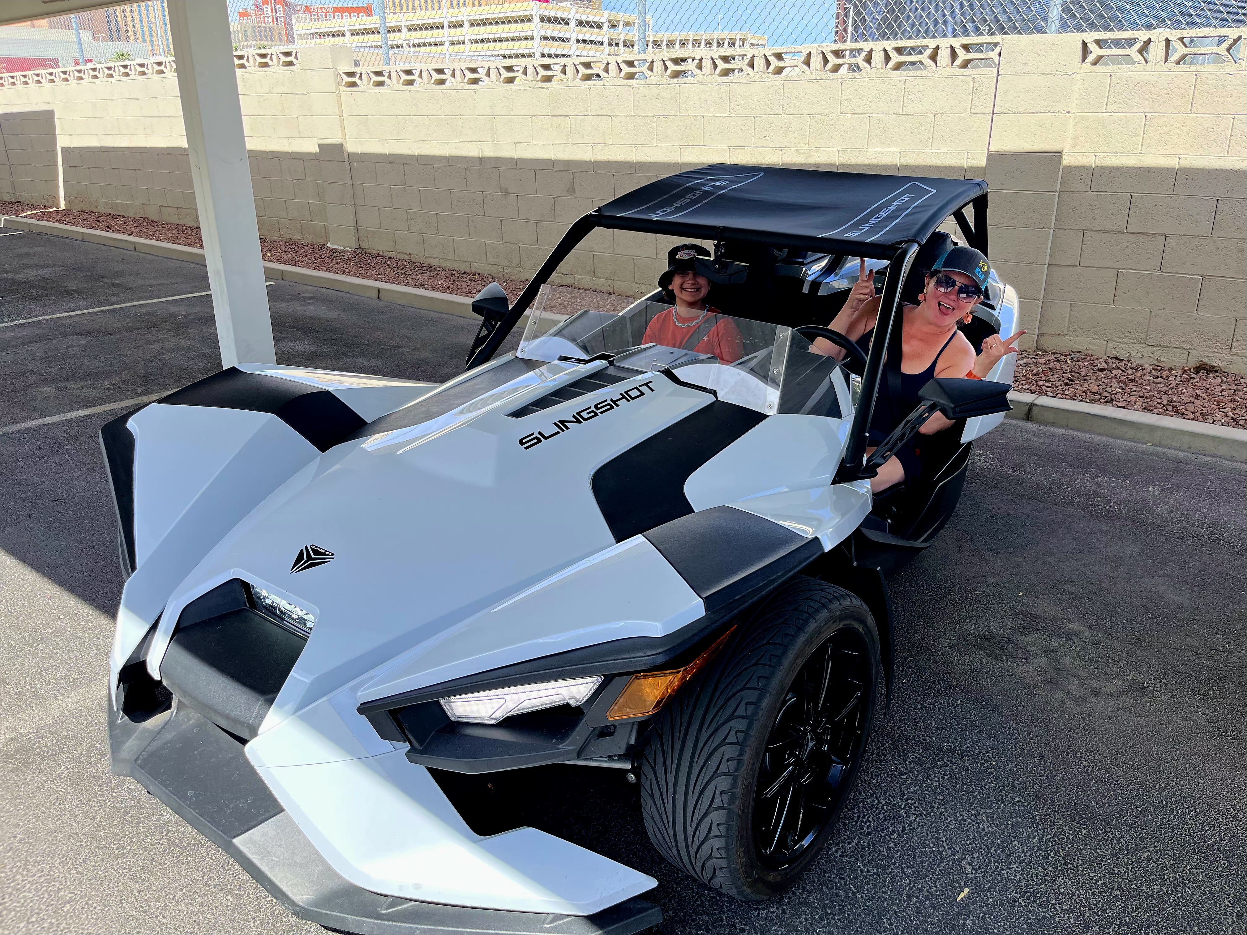 Two women in white Slingshot in parking lot