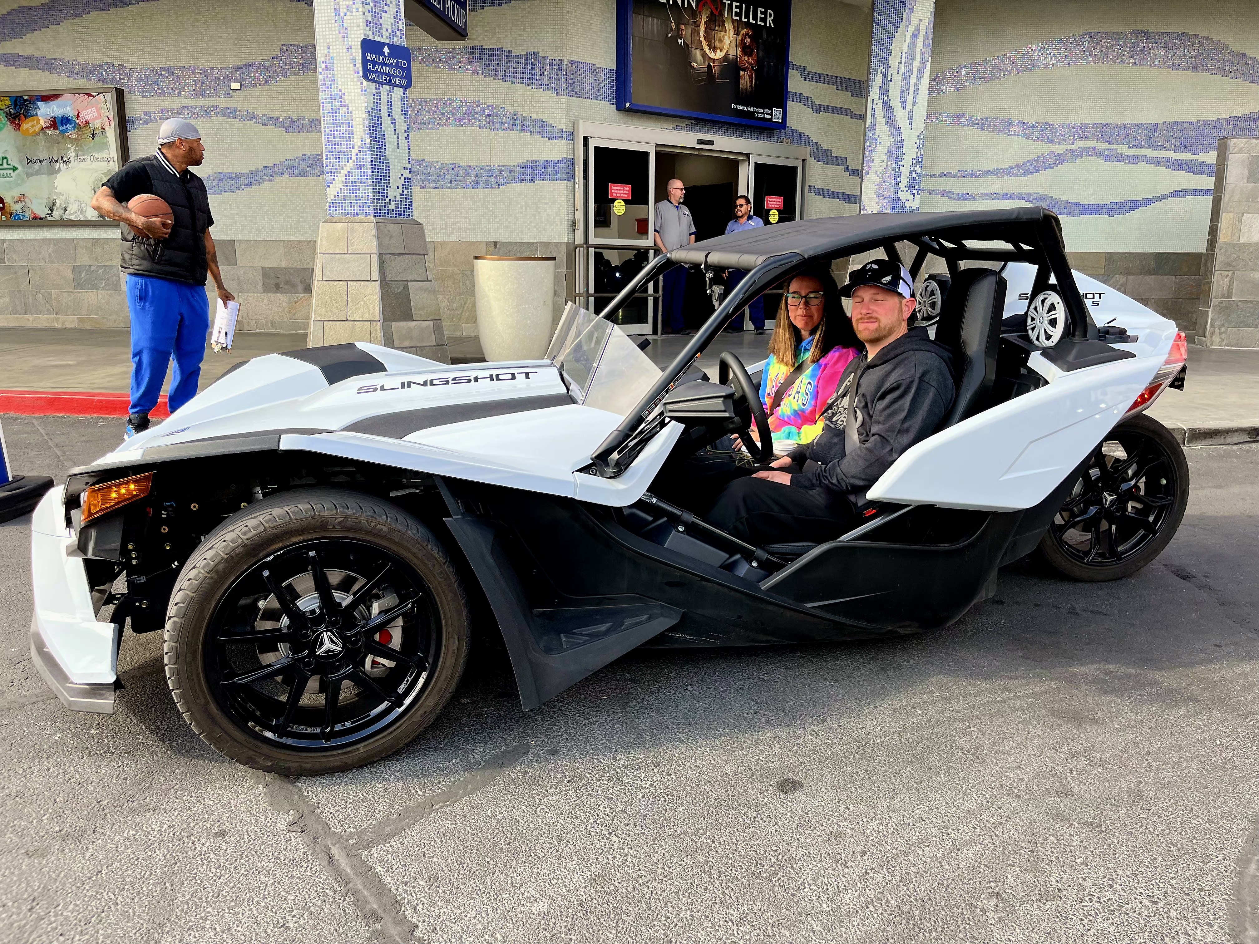 Couple in white Slingshot outside Penn & Teller