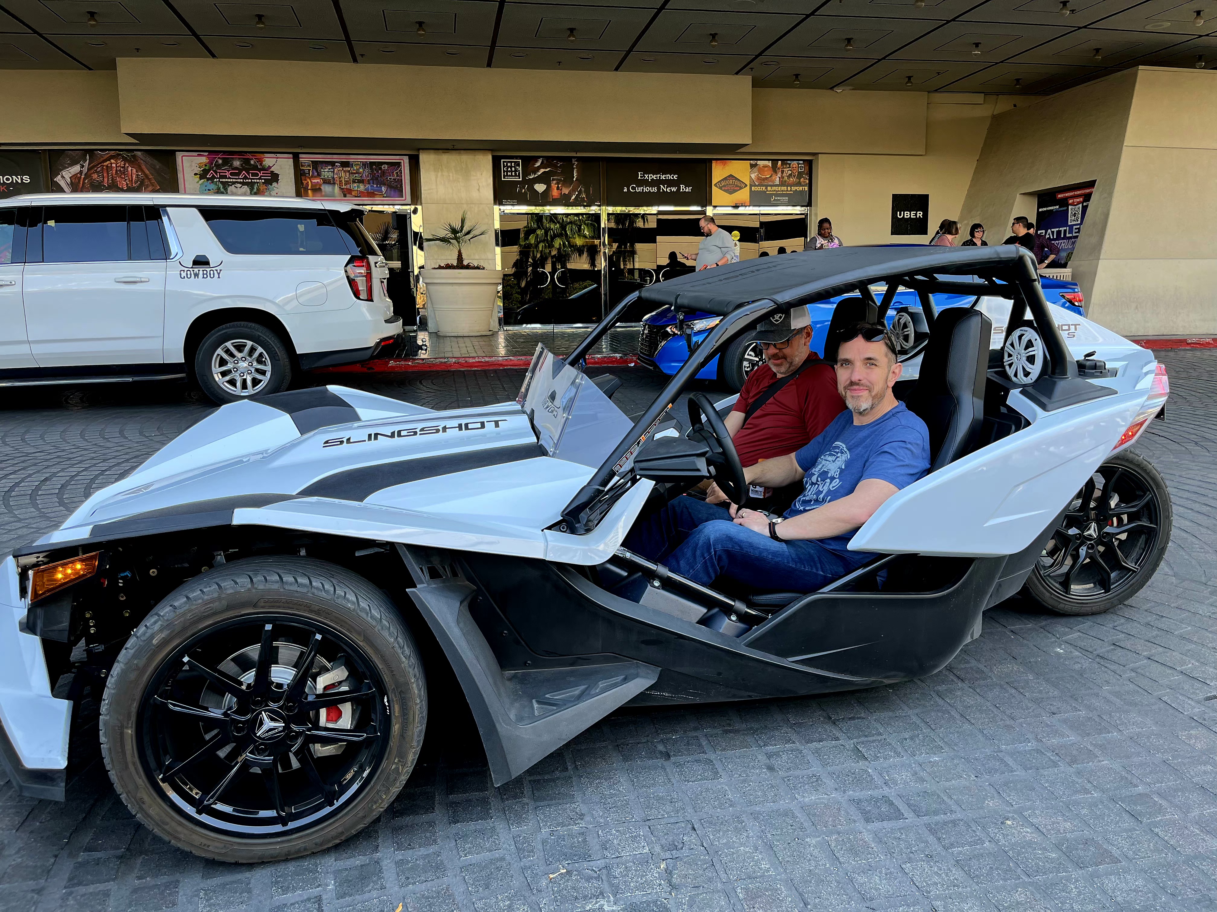 Two men in white Slingshot at casino entrance